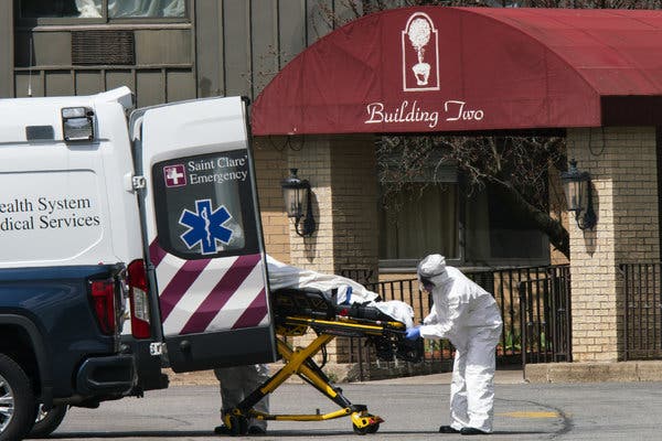 Medical workers in protective great outside a residence in Andover, N.J.