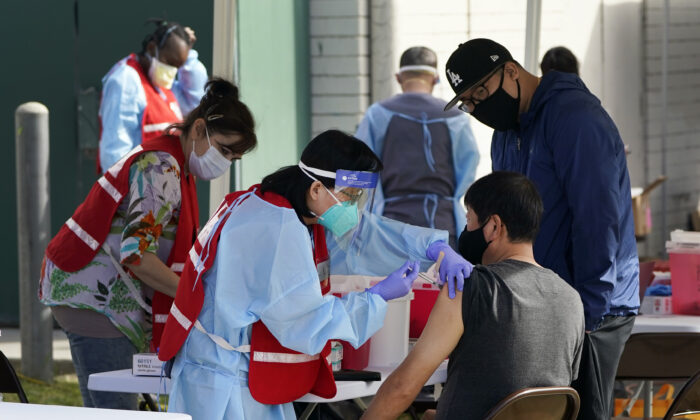 Health care workers receive a COVID-19 vaccination at Ritchie Valens Recreation Center in Pacoima, Calif., on Jan. 13, 2021. (Marcio Jose Sanchez/AP Photo)